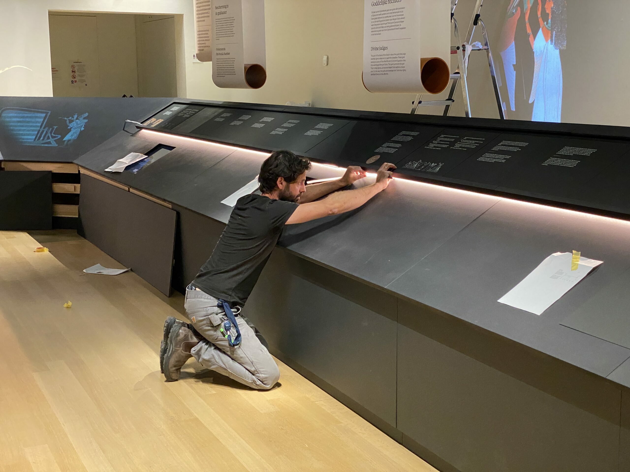 Image for De LED strip in het meubel van het dodenboek van Qenna wordt aangebracht